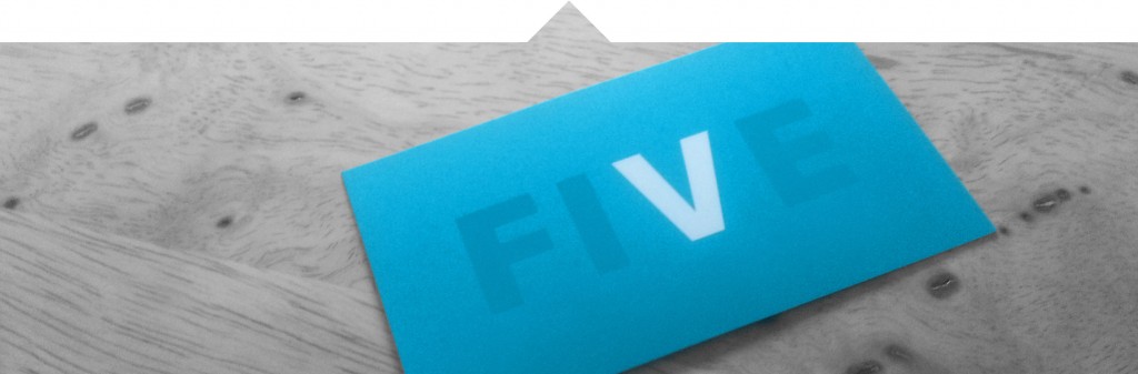 Five namecard photographed on butcher block table